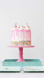 A book is like a cake, and this cake is white with pink drizzles and rainbow sprinkles.
